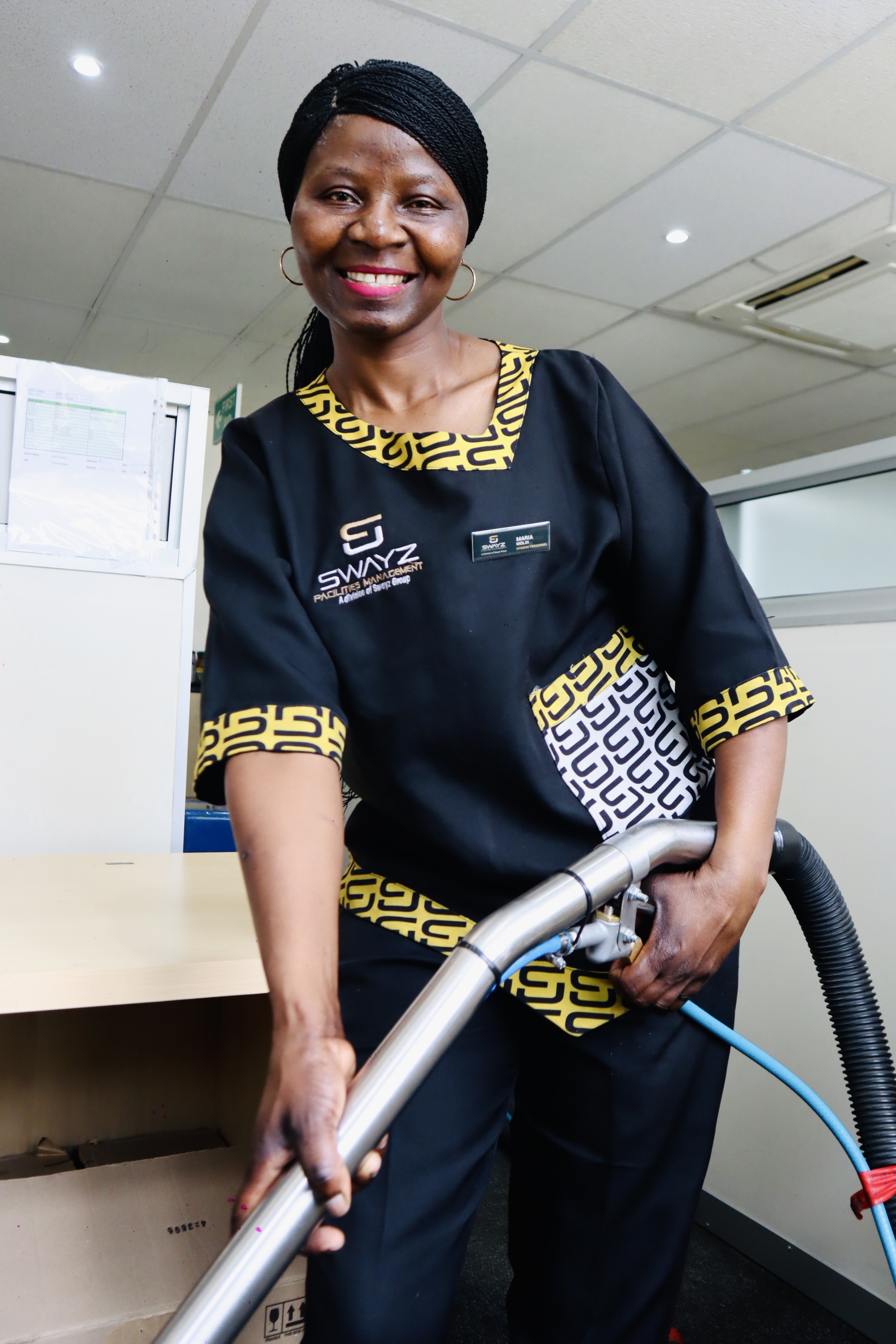 Swayz Facilities Management team member smiling while cleaning
