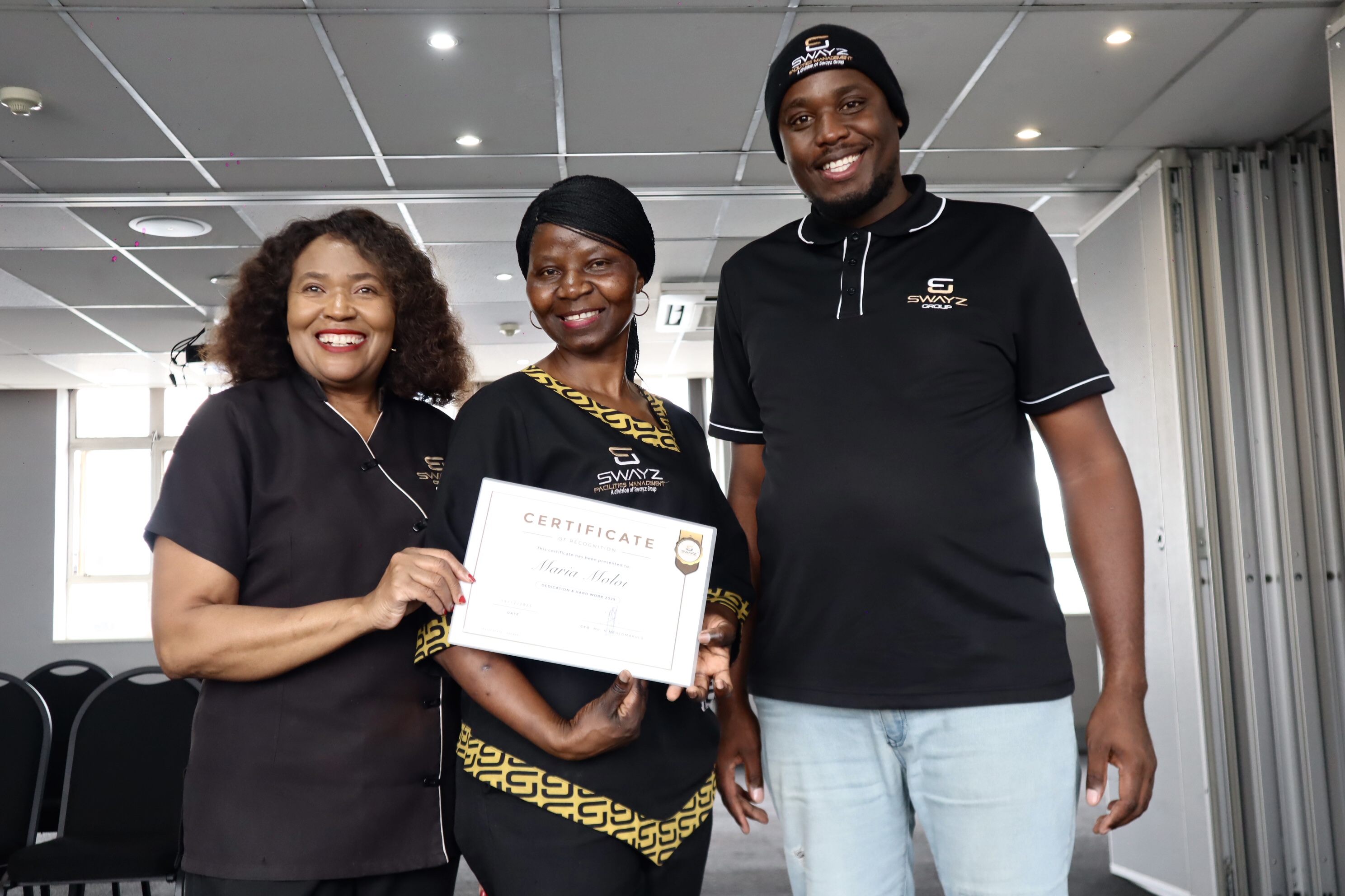 Swayz Facilities Management team member receiving a certificate